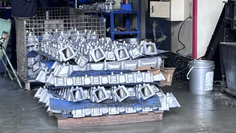 Groups of metal cast components arranged on workshop pallets