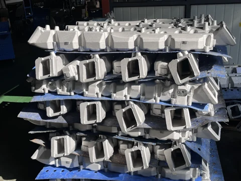Rows of cast components with rectangular openings on blue separators